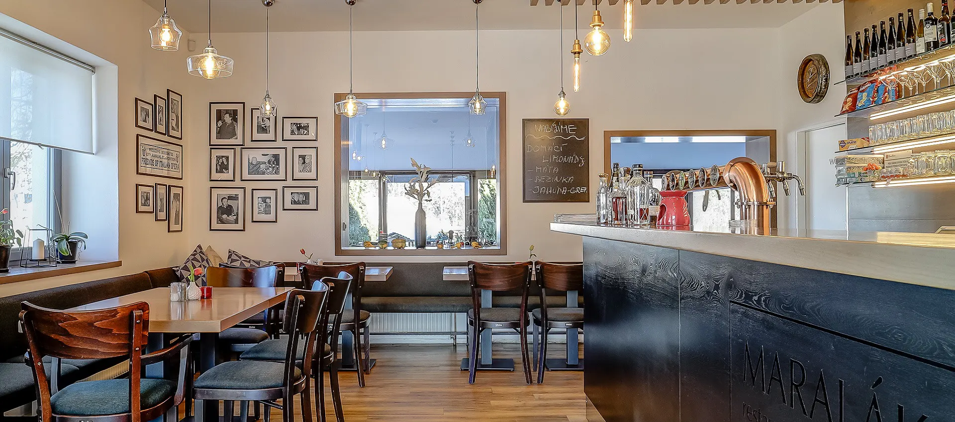 Hotel Maralák restaurant with wooden tables and large windows overlooking the garden