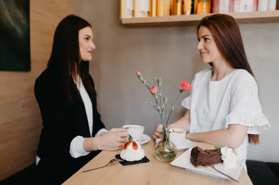 Dvě ženy u pracovní schůzky nad kávou v kavárně hotelu Maralák