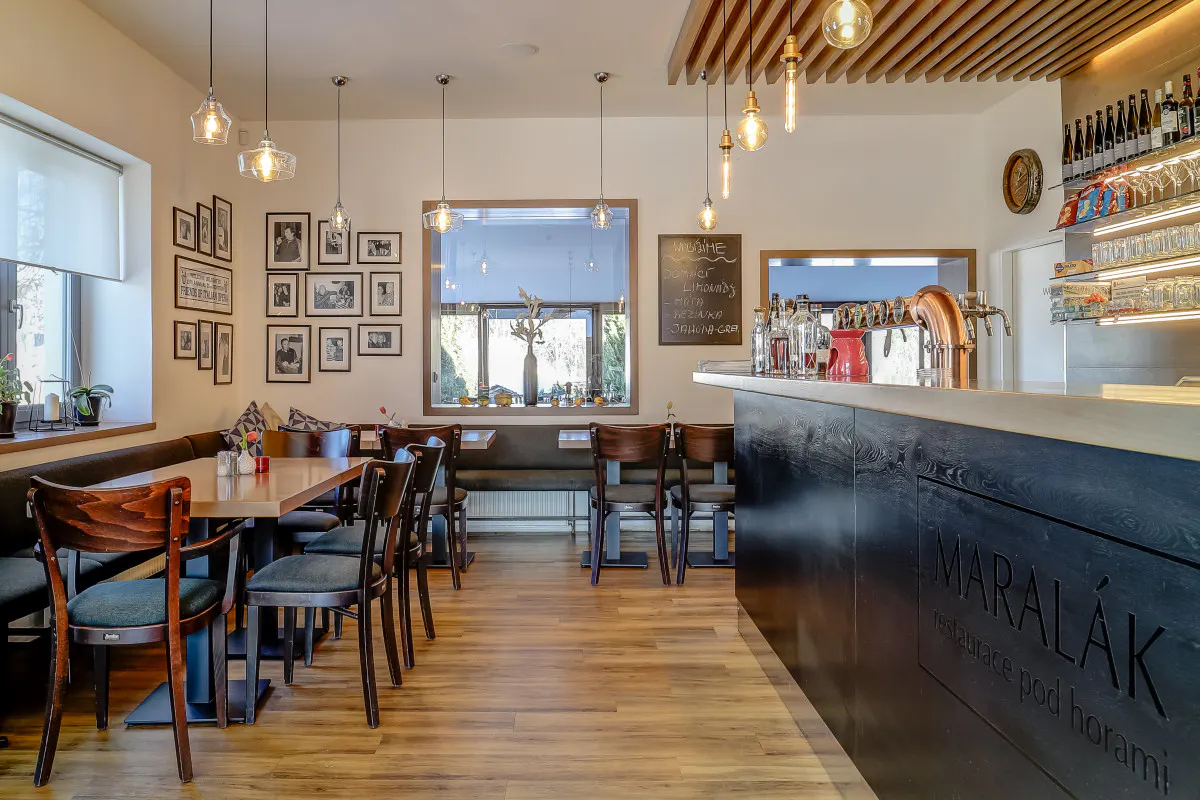 Bar restaurace Maralák s měděnou pípou a nápisem Maralák — restaurace pod horami